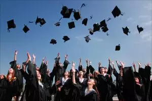 college students tossing caps into the air