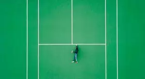 aerial view of people lying down on empty tennis court