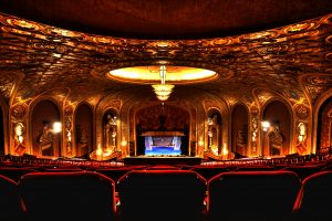 an ornate theater seen from the back of the room in a chair