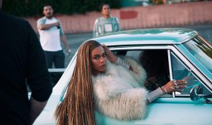 beyonce hangs outside a car window during a still from a music video