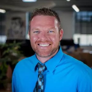 a man smiles while standing in an office