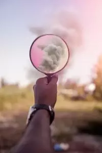 Pink magnifying glass held up to the clouds.