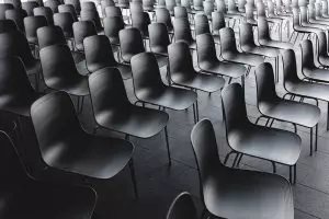 rows of empty chairs line a dark room