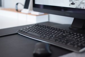 A computer keyboard on an office desk.