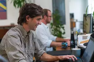 Two content marketing professionals working at their desks at the Oneupweb office.