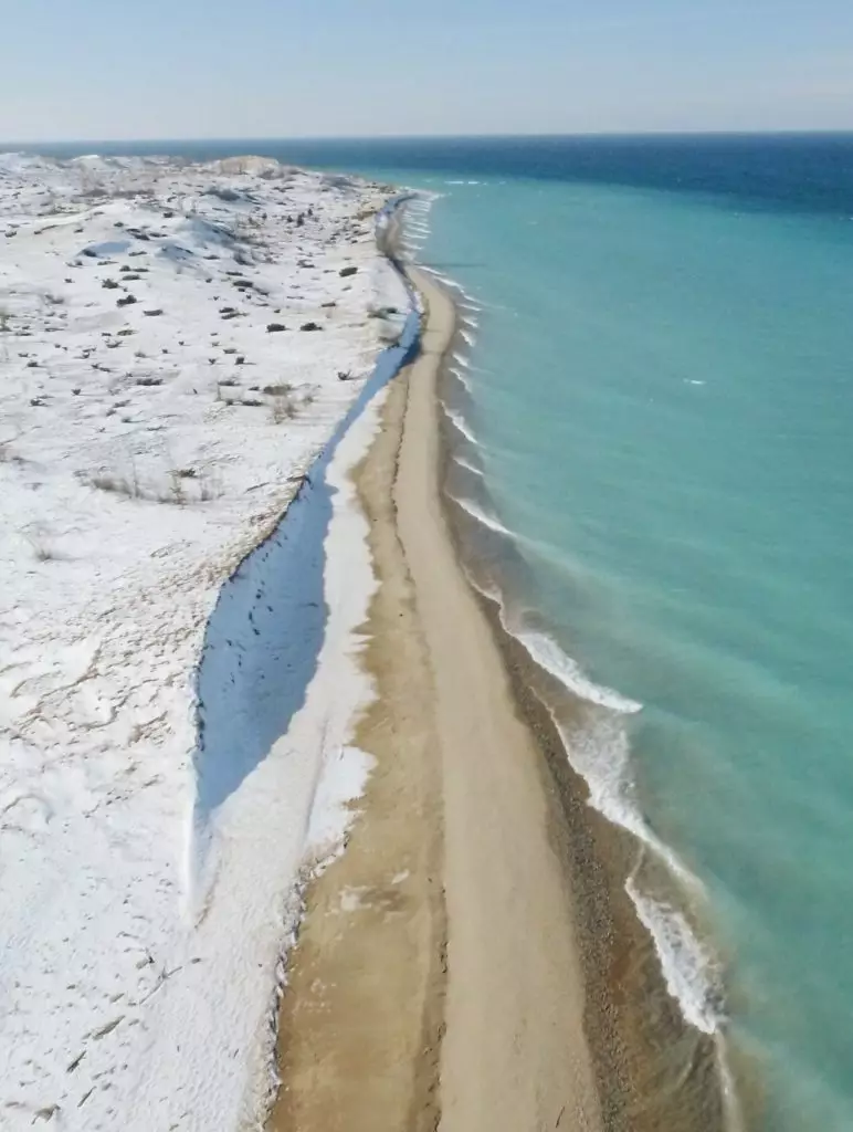 overhead shot of beach in winter with blue water