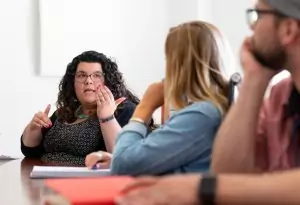 website design and development professionals talking at conference table