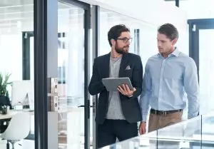 Shot of two businessmen using a digital tablet together in an office