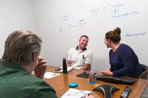 three people sitting in a conference room