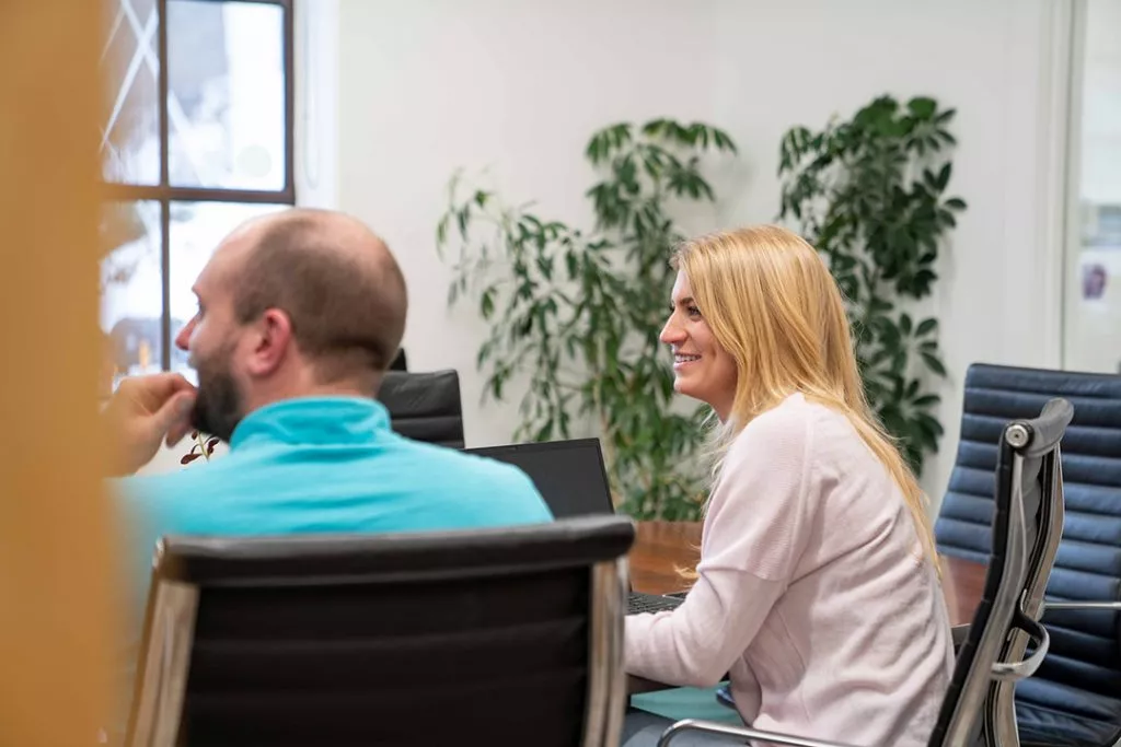 Two marketing employees watch a presentation