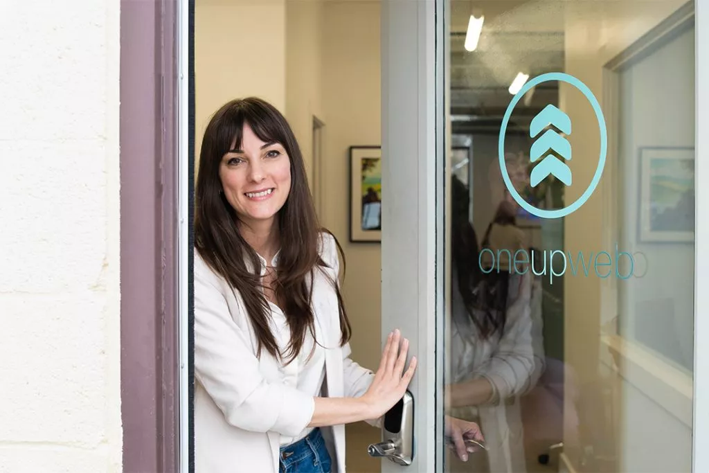 Oneupweb's front door being opened by Kristen, our front desk administrator