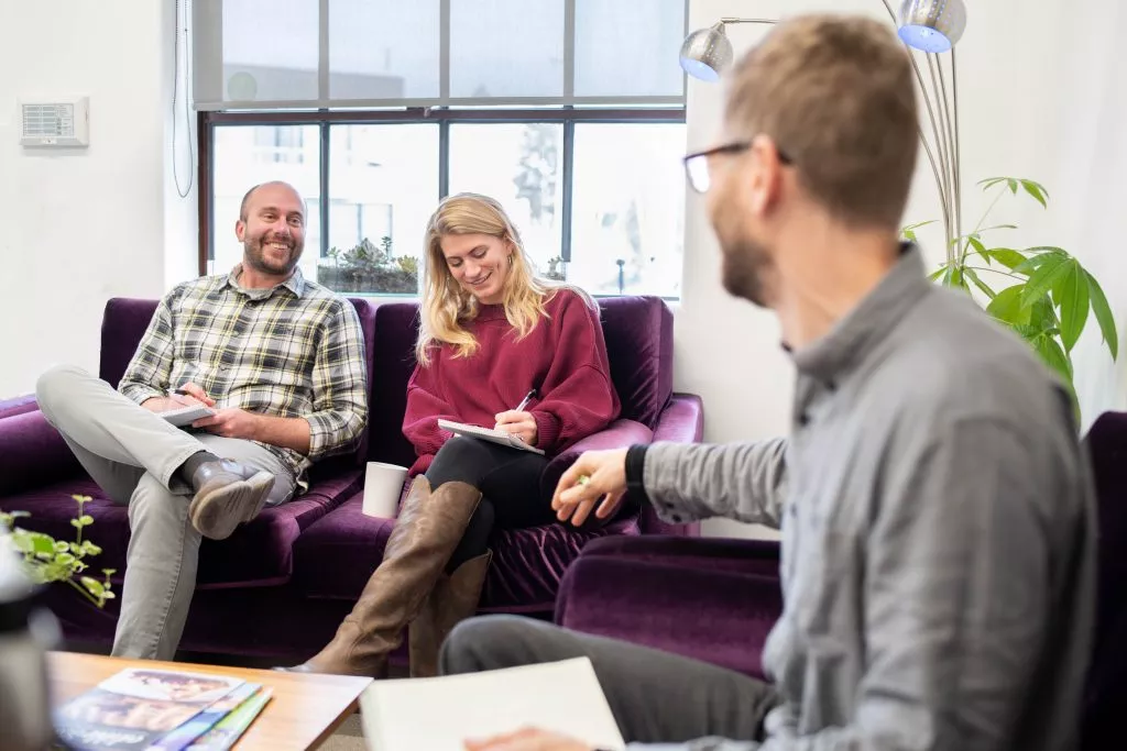 people sitting on couches and holding notebooks