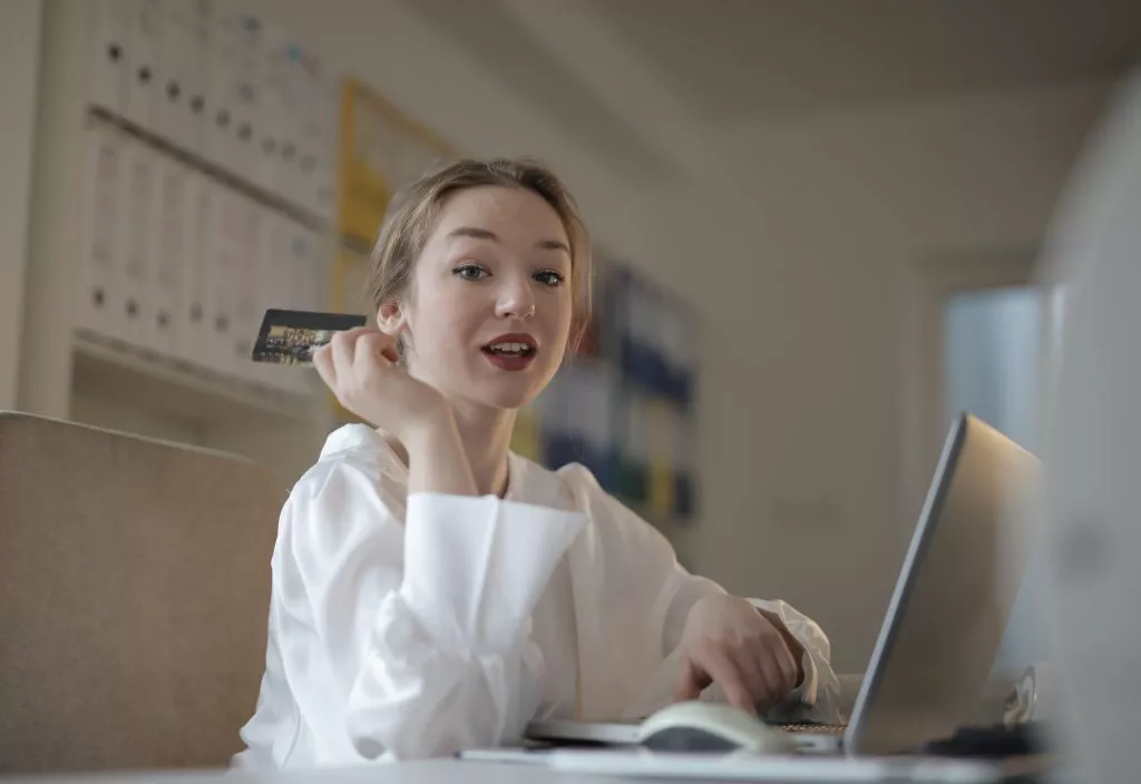 Young woman making credit card purchase on laptop