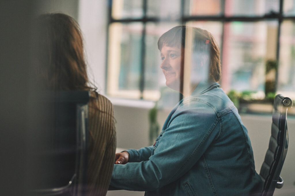 Marketers work in a glass-walled conference room.