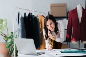 A woman takes a customer order over the phone in a boutique store.