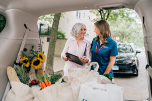 A homecare worker assists an elderly client with groceries.