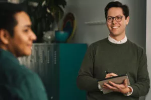 two marketers work and smile while standing taking notes