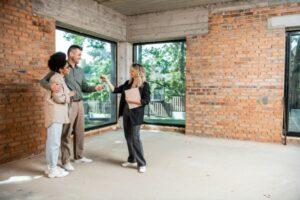 A real estate agent works with a young couple inspecting a home.