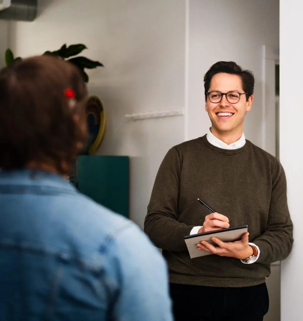 oneupweb marketer taking notes while talking to a client