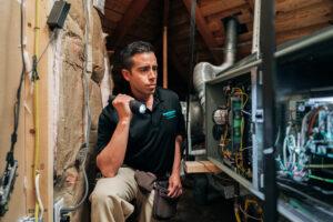 an employee shines a flashlight while inspecting a house